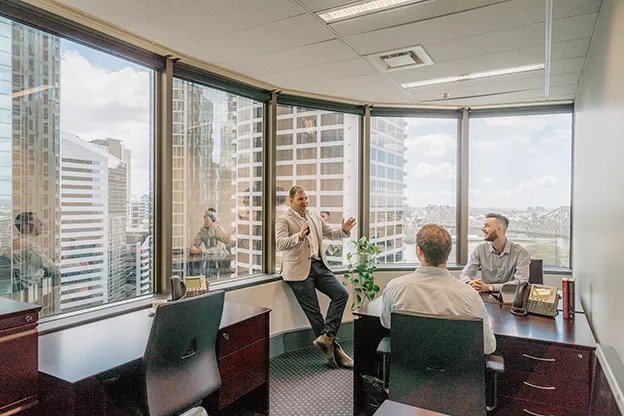 A team meeting in a modern Servcorp office with panoramic views, boost productivity in a professional workspace.