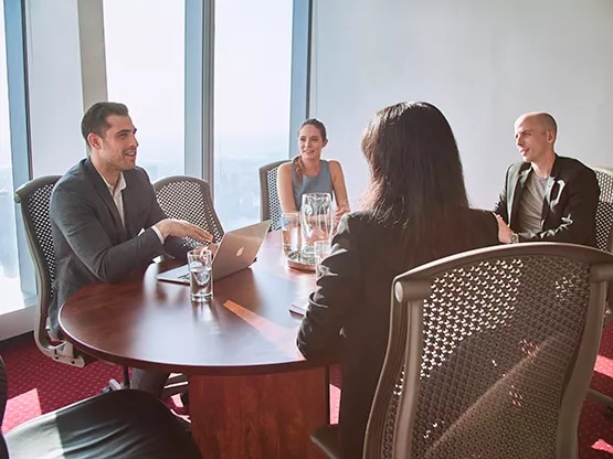 Professionals collaborate in a Servcorp meeting room with skyline views, ideal for strategy and planning,